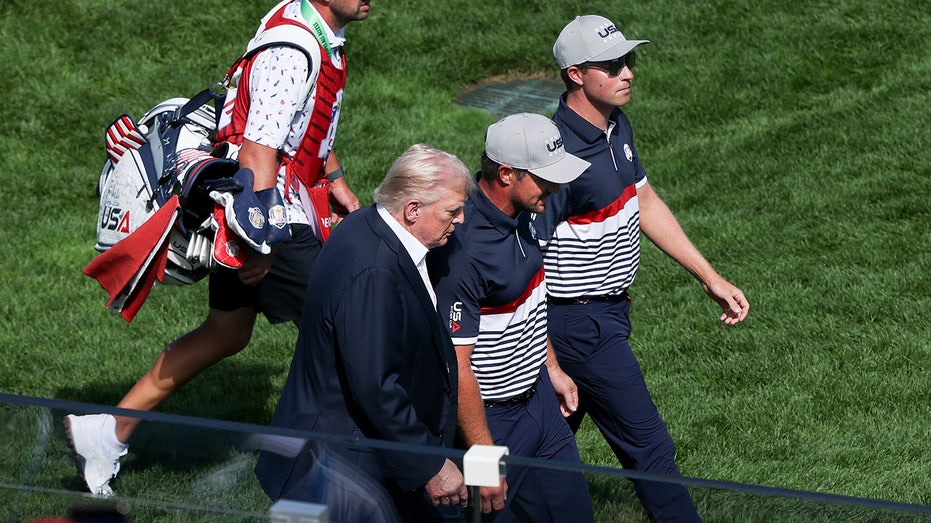 Трамп приветствует Брисона Дишамбо на Райдър Кап перед началом второй сессии Thumbnail